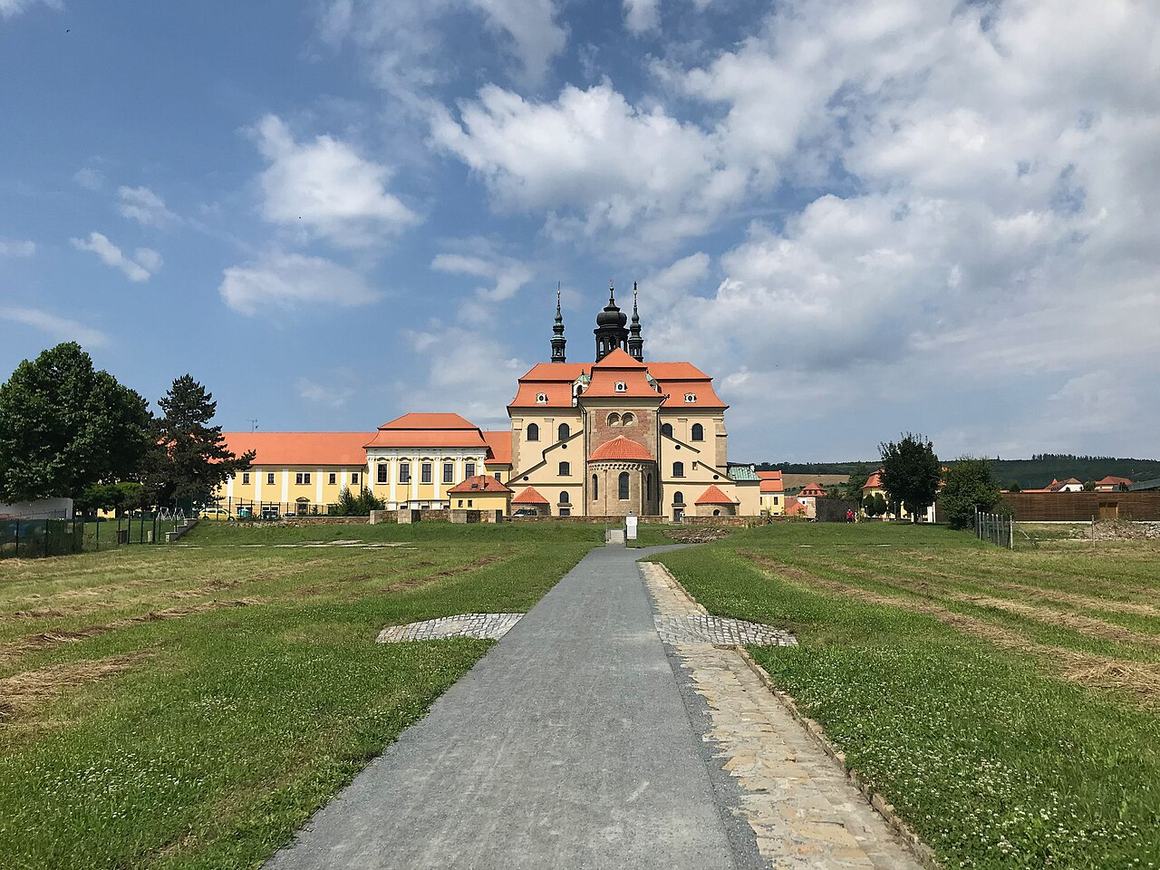 A long straight path across a lawn leading to the Velehrad basilica