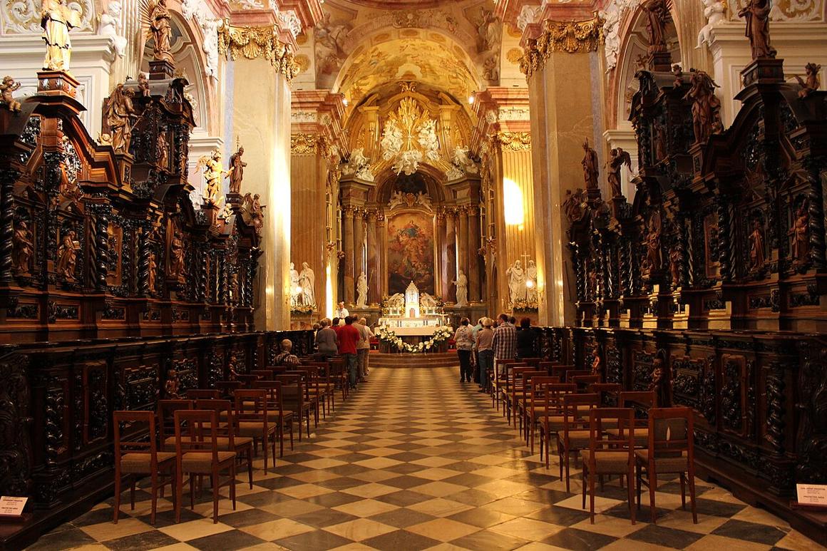 The gilded Baroque nave of the Velehrad basilica lined with carved choir stalls