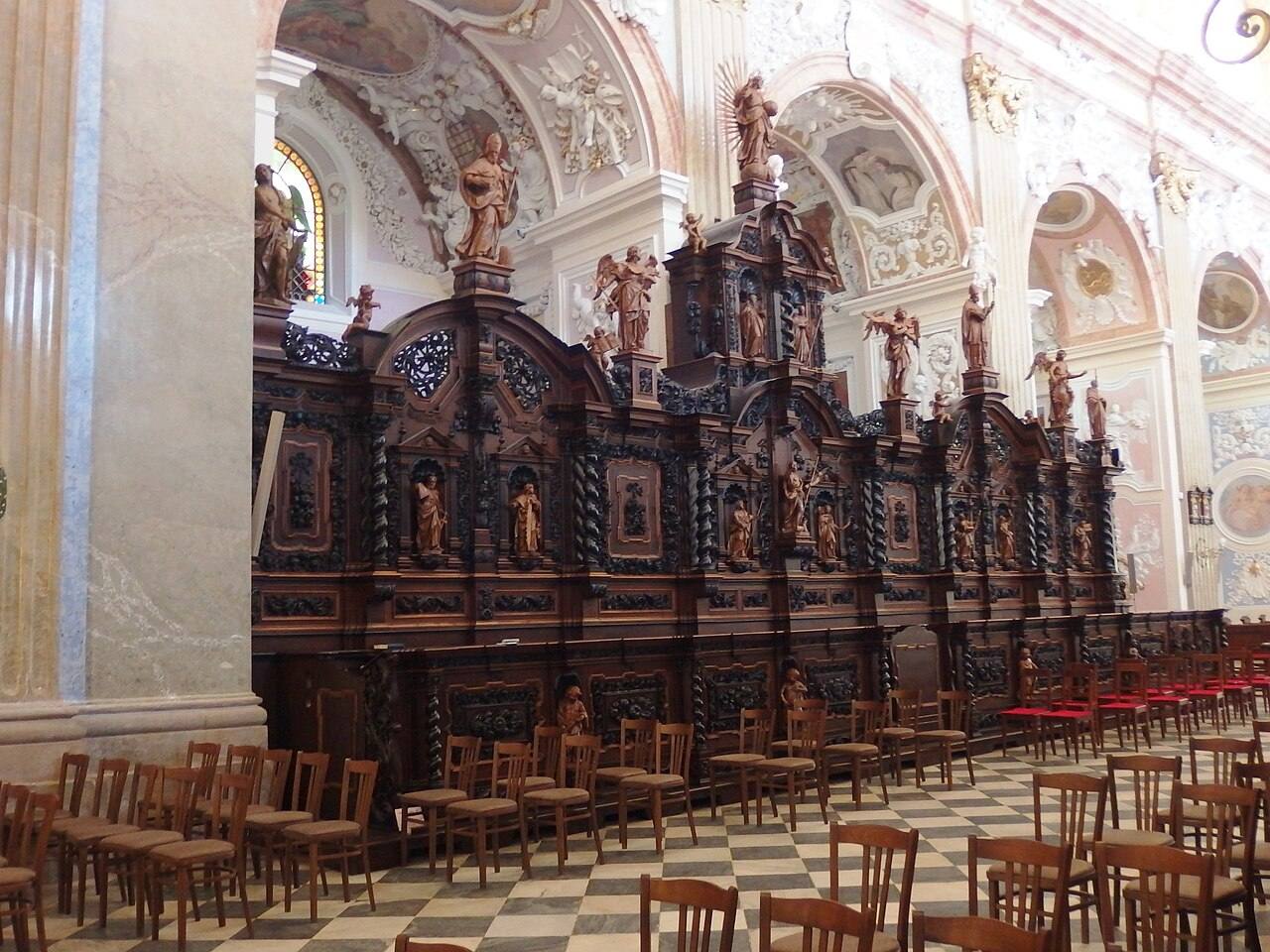 Dark carved Baroque choir stalls with statues of saints and angels in the Velehrad basilica