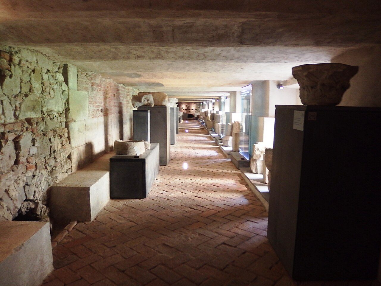 A long underground passage beneath the Velehrad basilica lined with Romanesque stone fragments