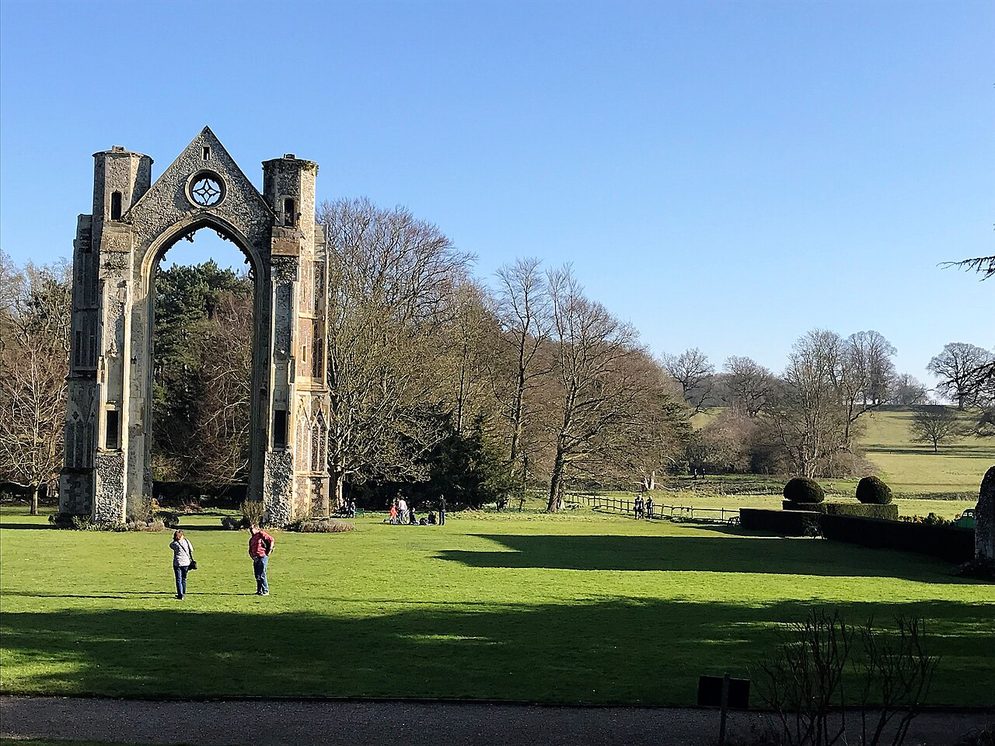 The tall ruined east window arch of Walsingham Priory standing alone in parkland, Little Walsingham, Norfolk
