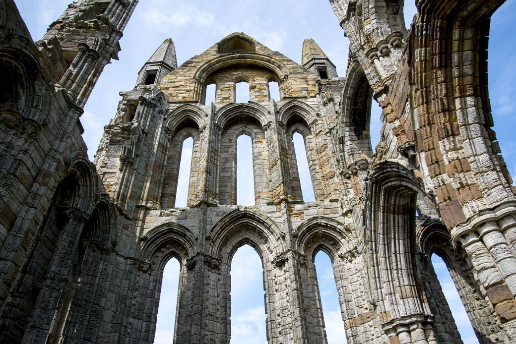 Looking up at the ruined Gothic arches and windows inside Whitby Abbey