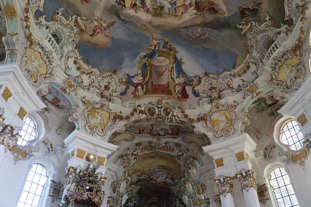 The painted ceiling of the Wieskirche, a bright sky full of figures framed by white and gold stucco