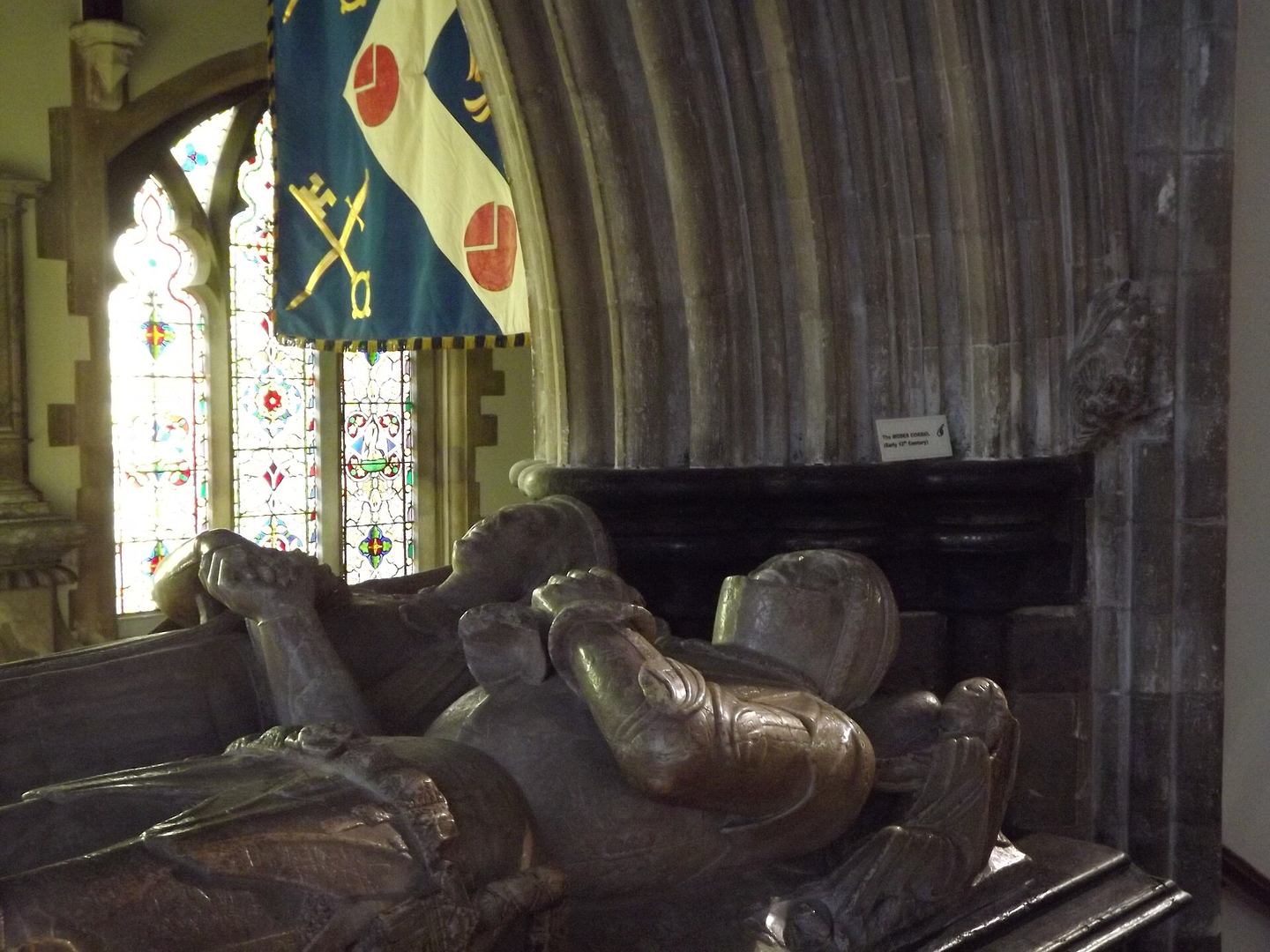 Alabaster effigies of a knight and his wife lying side by side on a tomb chest