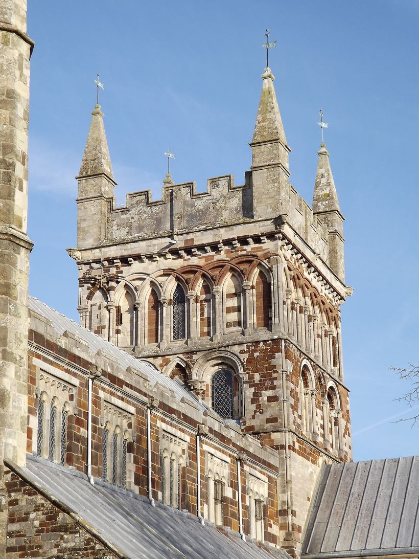 The central tower of Wimborne Minster with its Norman arcading and corner pinnacles