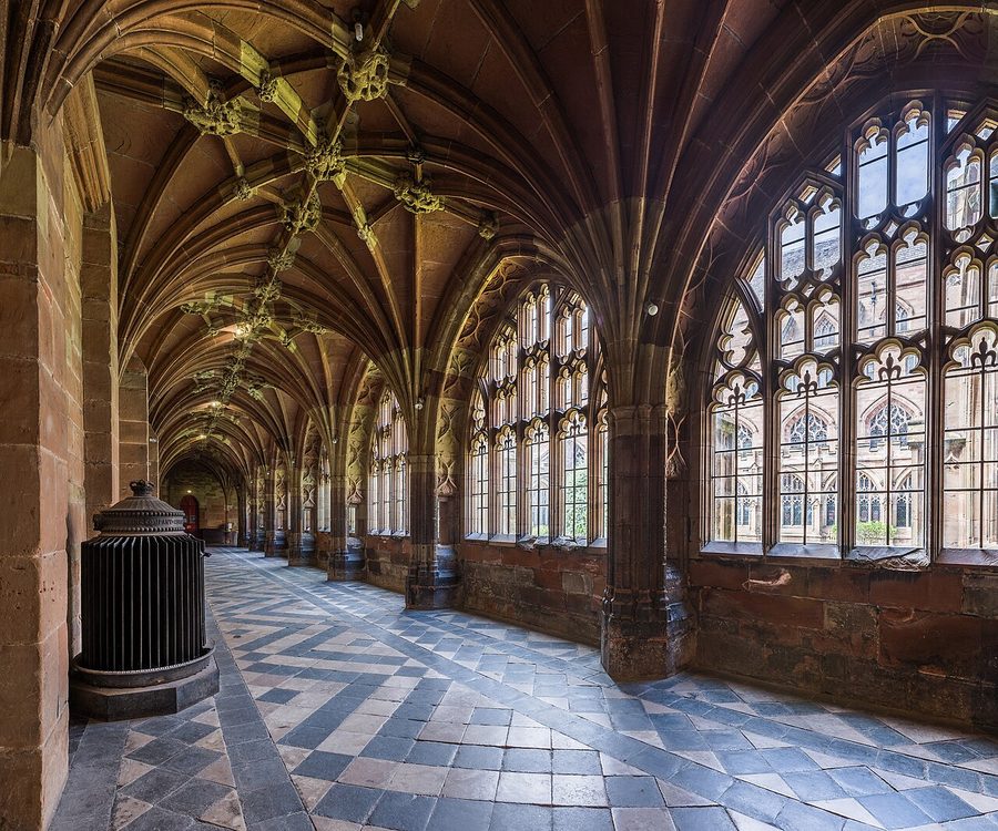 The vaulted cloister walk at Worcester Cathedral with tall traceried windows
