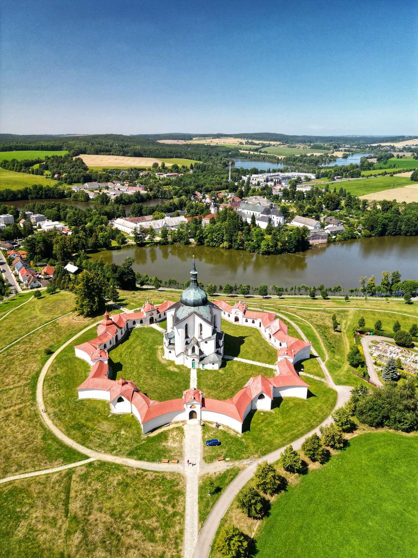 Aerial view of the Zelená Hora pilgrimage church and its star-shaped cloister above a lake