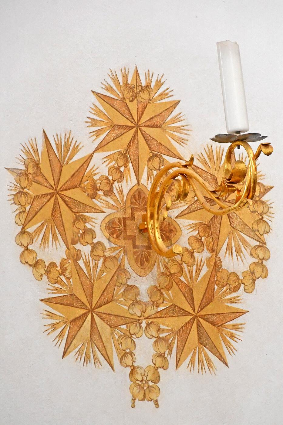 A gilded wall candlestick made of five-pointed stars in Zelená Hora church